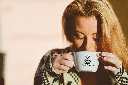 Woman Drinking Coffee from Caffee Romanza Cup Image