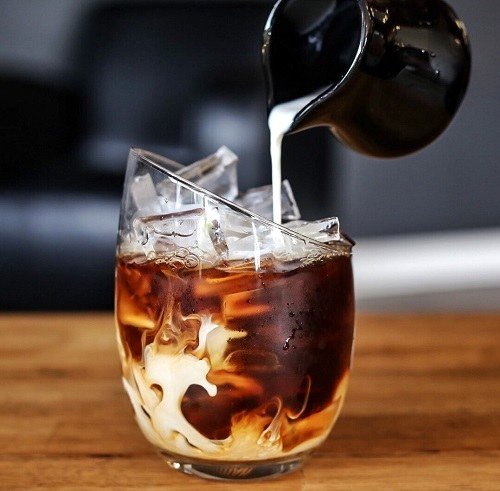 Pouring Cream into a Glass of Cold Brew Coffee