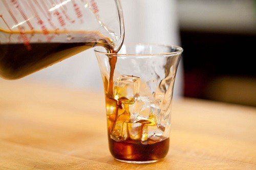 Pouring Cold Brew Iced Coffee into a Glass filled with Ice