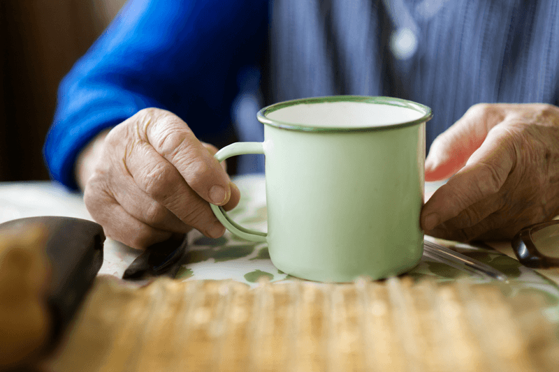 Elderly Person With A Cup Of Low Acid Coffee