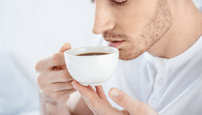 Young Man Drinking Coffee Before Bed