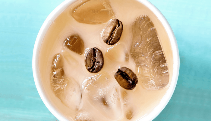 Frappe With Coffee Beans Floating In It On A Blue Background