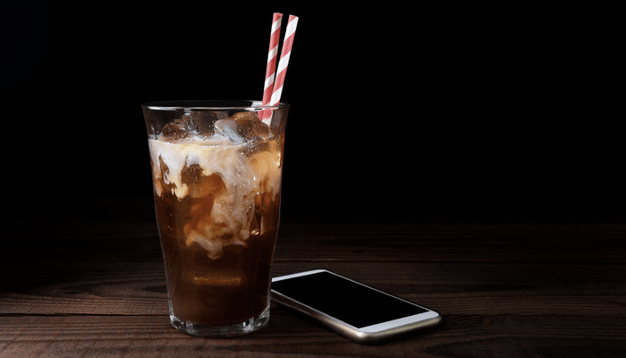 Iced Coffee With A Cell Phone On Dark Background