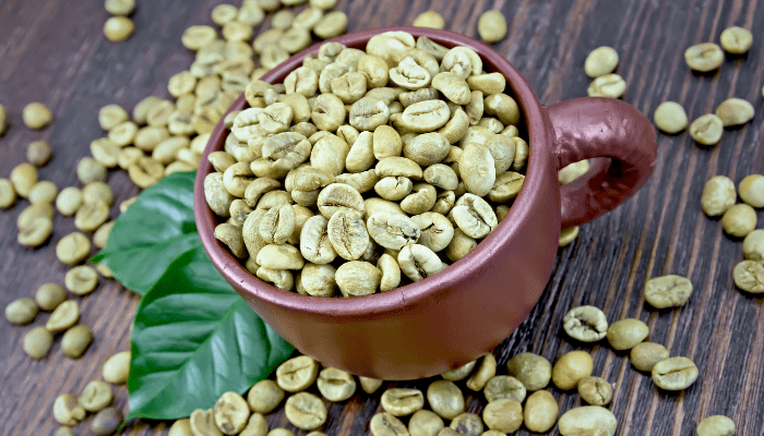 Non Roasted Coffee Beans In A Brown Mug On Wooden Background