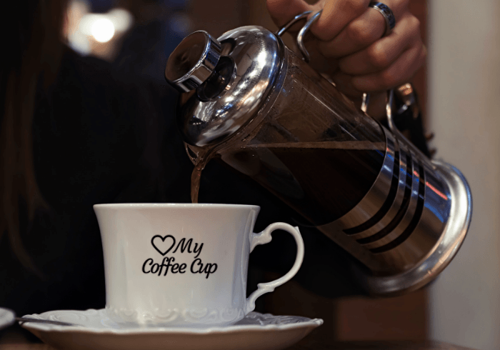 French Press Pouring Into Coffee Cup