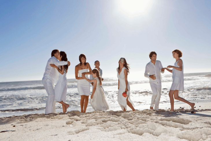 The wedding party having fun on the beach at destination wedding