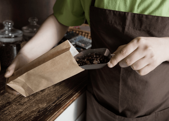 Shop owner putting decaf beans into a bag