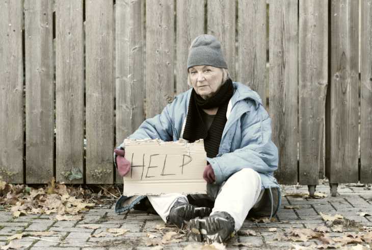 Homeless woman holding a help sign