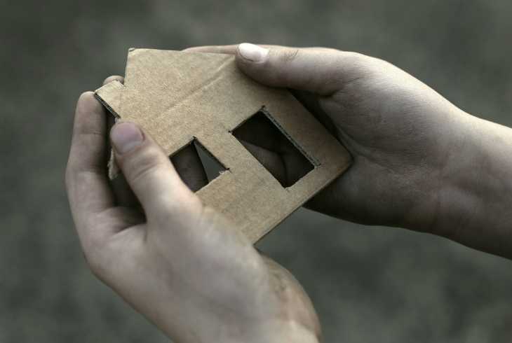 Pair of hands holding a cardboard house outline