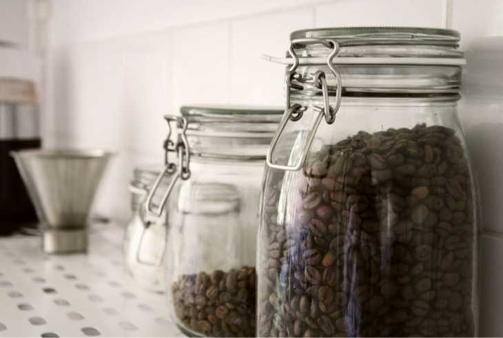 Two airtight jars with coffee beans on a counter