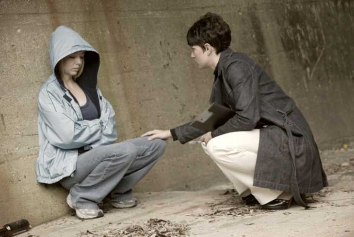 Homeless teenager talking to a woman trying to help