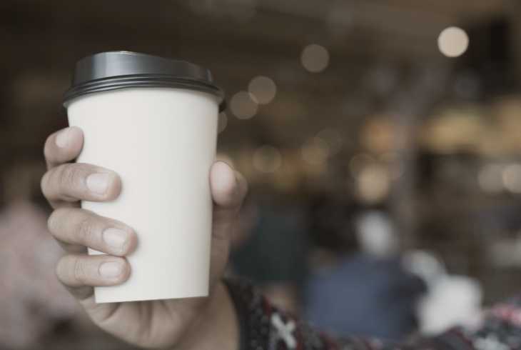 Hand holding a cup of decaf coffee