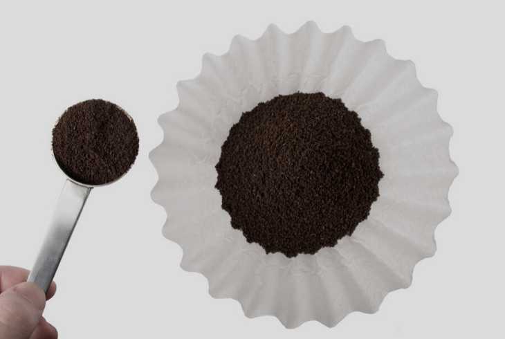 Measuring coffee with scoop and putting it in the coffee filter