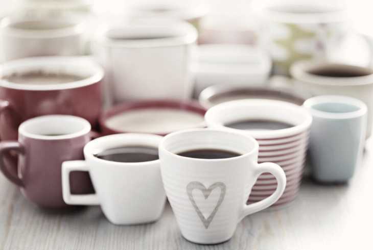 A bunch of full coffee cups on a table