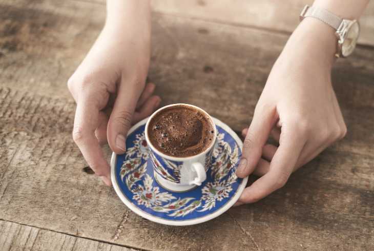 Pair of hands serving Turkish coffee